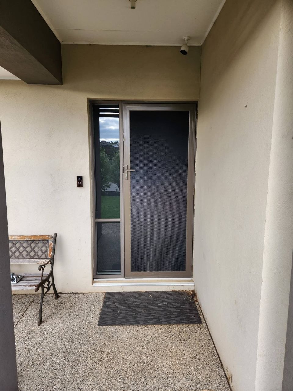 Light brown security door with sidelight, beige house exterior
